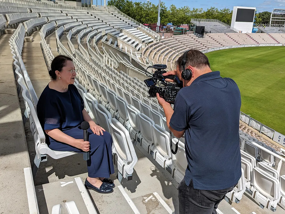 Marcus of Media2u filming an interview in the stands of a sports stadium